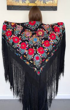 Here is a heavily embroidered 1920s antique silk shawl. The richly coloured and vibrant embroidery is in an unusual floral design that I have not seen before in all my years of collecting this type of shawl. It features large and smaller flowers and it has been worked in colours including red and blue with orange highlights. This wonderful shawl has long fringing and a hand knotted deep border to each side. These shawls are beautiful to wear as they have lovely movement when worn (see the video Bohemian Floral Embroidered Shawl For Festival, Bohemian Embroidered Shawl Fabric, Bohemian Shawl With Floral Embroidery For Festival, Bohemian Shawl With Intricate Multicolor Embroidery, Red Bohemian Shawl With Floral Print, Bohemian Shawl With Embroidered Border For Festival, Bohemian Shawl Scarf With Intricate Embroidery, Bohemian Shawl Scarves With Intricate Embroidery, Folk Shawl With Embroidered Border