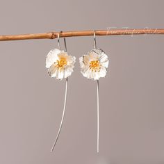 These Poppy Flower Drop Earrings, crafted from premium 925 silver, are an homage to the subtle power of nature's artistry. With petals that display a lifelike texture and a center delicately brushed with gold, they capture the wild and free essence of poppies in bloom. Lightweight and with a gentle sway, they offer a whisper of movement, a dash of sophistication to your daily wear or a statement piece for special occasions. Let these earrings be a symbol of resilience and beauty, mirroring the e White Sterling Silver Pierced Flower Earrings, White Sterling Silver Threader Earrings, White Sterling Silver Flower Earrings For Pierced Ears, Adjustable Sterling Silver Flower Earrings, Sterling Silver Adjustable Drop Flower Earrings, Adjustable Sterling Silver Drop Flower Earrings, Delicate Silver Earrings With Birth Flower, Delicate Silver Birth Flower Earrings, White Birth Flower Sterling Silver Earrings