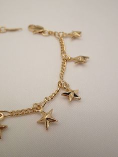 The stars lined up when this beauty was created! The Star Bracelet is one superstar! This star charm bracelet features an infinity dainty bracelet adorned with tiny puff star charms. Best of all, she comes in anklet form too! Your sure to stir a sensation with this cutie! Knock this look out of this galaxy with these must have star jewelry pieces too! - The Star Choker Necklace - The Starburst Earrings - The Moon and Star Necklace Available in 24K gold or rhodium plating over steel Size: 7" (we Adjustable Gold Chain Bracelet With Star Charm, Adjustable Star Charm Chain Bracelet, Gold Star Charm Chain Bracelet, Gold Chain Bracelet With Star Charm, Adjustable Gold Star Chain Bracelet, Adjustable Gold Star-shaped Chain Bracelet, Dainty Star Charm Bracelet, Gold Star Charm Bracelet, Gold Anklet With Star Charm As Gift