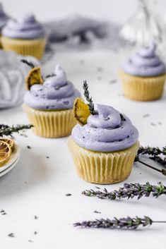 three cupcakes with purple frosting and lavender sprinkles