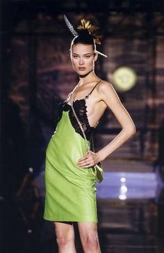 a woman in a green dress on the runway