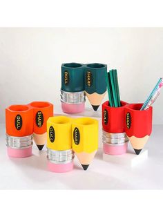 several different colored pencils and markers in cups