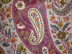 a close up view of the back of a purse with flowers and paisley designs on it