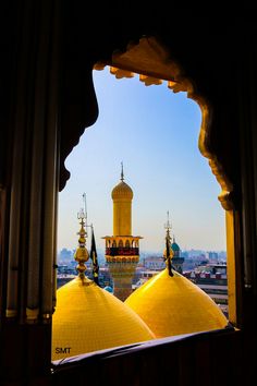 the view from inside an ornate building with yellow domes