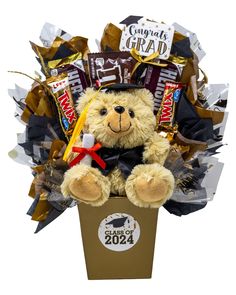 a teddy bear in a gift box filled with chocolates and candies for graduation