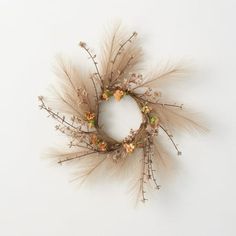 a wreath made out of dried flowers and twigs on a white background with space for text