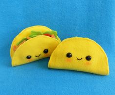 two stuffed tacos are sitting on a blue surface