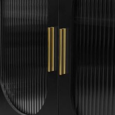 a black and gold cabinet with two brass handles