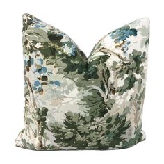 a green and blue floral pillow on a white background