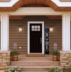 the front entrance to a house with two planters on either side