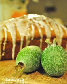 two green apples sitting on top of a cutting board next to a loaf of bread