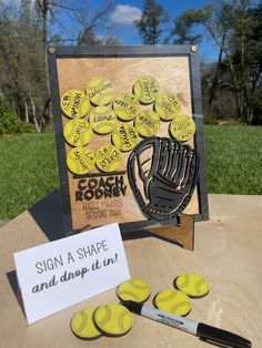 a table topped with lots of magnets next to a sign and baseball mitt