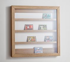 a wooden framed display case filled with different types of match cards on white wall background