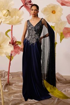 Navy blue draped gown with clematis moonlet bloom embroidery on the yoke using cutdana, sequin, crystals highlights, dangling cutdana strings and one sided mesh jaal drape embellished with crystals detailing. - Aza Fashions Olive Gown, Sari Gown, Crystal Gown, Shiny Crystals, Gowns Blue, Draping Techniques, Navy Blue Gown, Detachable Cape, Satin Embroidery