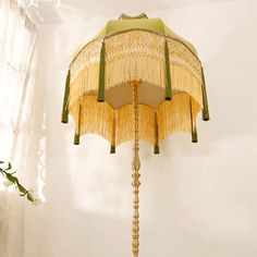 a floor lamp that is on top of a table next to a vase with flowers