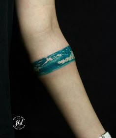 a person's arm with a wristband covered in watercolors on it