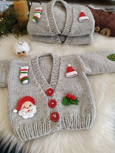 two knitted christmas sweaters, one with santa's hat and the other with buttons