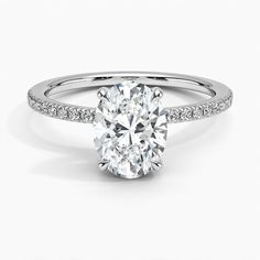 an oval cut diamond engagement ring with pave set shoulders