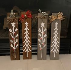 three wooden christmas decorations sitting on top of a fireplace