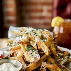 french fries with parmesan cheese and ketchup on a plate next to dipping sauce