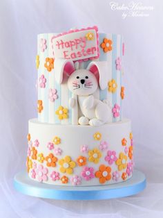 a cake decorated with flowers and a bunny on the top is for an easter celebration