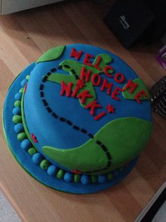 a blue and green cake sitting on top of a wooden table