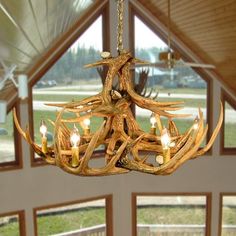 a chandelier made out of antlers and candles hanging from it's ceiling