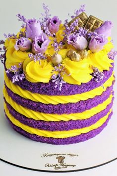 a purple and yellow cake with flowers on top