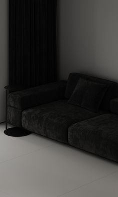 a black couch sitting in front of a window