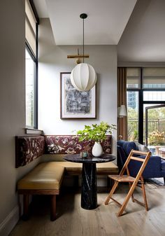 a living room filled with furniture next to a window and a painting on the wall