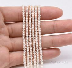 three strands of white pearls are being held by someone's hand