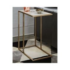 the side table has a glass top and gold metal frame with a white marble top