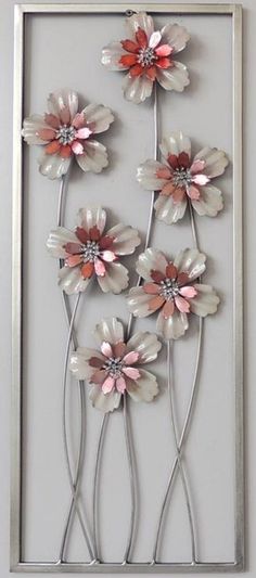 a metal flower wall hanging on the side of a wall in front of a mirror