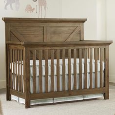 a baby crib in a room with white carpeting and wooden accents on the walls