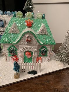 a christmas scene with a gingerbread house in the snow and candy canes all around