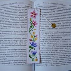 an open book with flowers on it and a gold button in the middle is shown