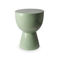 a green vase sitting on top of a white table