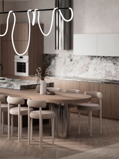 a kitchen with a table, chairs and lights hanging from it's ceiling over the counter