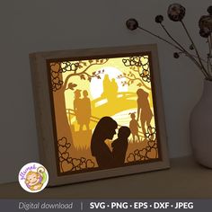 the silhouettes of people are shown in this paper cut art project, which is displayed next to a vase with dried flowers