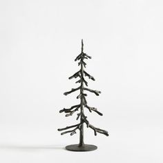 a small tree made out of branches on top of a metal stand with white background