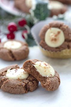 chocolate cookies with white frosting and bananas on top are sitting next to holly wreaths