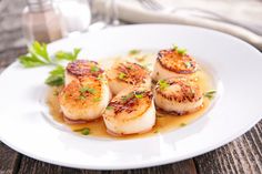 seared scallops are served on a white plate