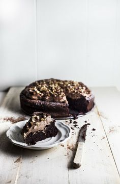 a piece of chocolate cake on a plate with a fork and knife next to it