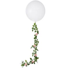 a white balloon with pink roses and greenery attached to it, floating in the air