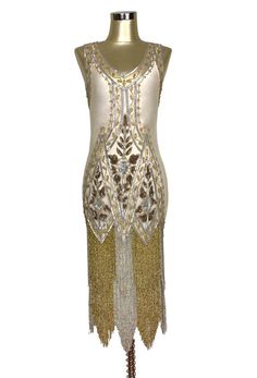 Our De Luxe Gown is a true work of art! Covered in decadent silver beadwork, the gown features a classic 1920's deco design and three layers of beaded fringe.  A low vneck front and back takes this gown to the next level in glamour. Comes with a matching satin slip. XS……bust 30-34", waist 26-30", hips 34-40", length 39