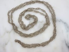 "A wonderful vintage long chain necklace with twisted wire links in silver tone metal. It is a Mexican wedding necklace, which would be worn around both the bride and groom while they saw their vows. No marks. Measures about 71\" long. Lots of tarnish and wear, I have not tried to clean or polish. Actual packaging will vary depending on item/s purchased and tape pattern available. Props shown in photos is for display purposes only, not included in this listing. As always, satisfaction is guarant Silver Chain Metal Necklace For Wedding, Silver Chain Necklace For Wedding, Wedding Silver Chain Metal Necklace, Wedding Metal Silver Chain Necklace, Antique Chain Necklace For Wedding, Silver Chain Link Jewelry For Wedding, Wedding Chain Link Necklace, Silver Rope Chain Necklace For Formal Occasions, Silver Adjustable Chain Necklace For Wedding