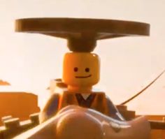 a lego man is sitting in front of the camera with his head turned to look like he's smiling