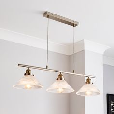 three lights hanging from the ceiling in a kitchen