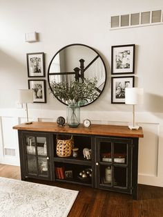 a room with a mirror, vase and pictures on the wall above it is featured in an instagram