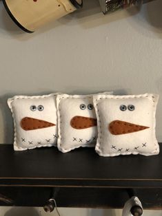 three pillows with faces are sitting on a table